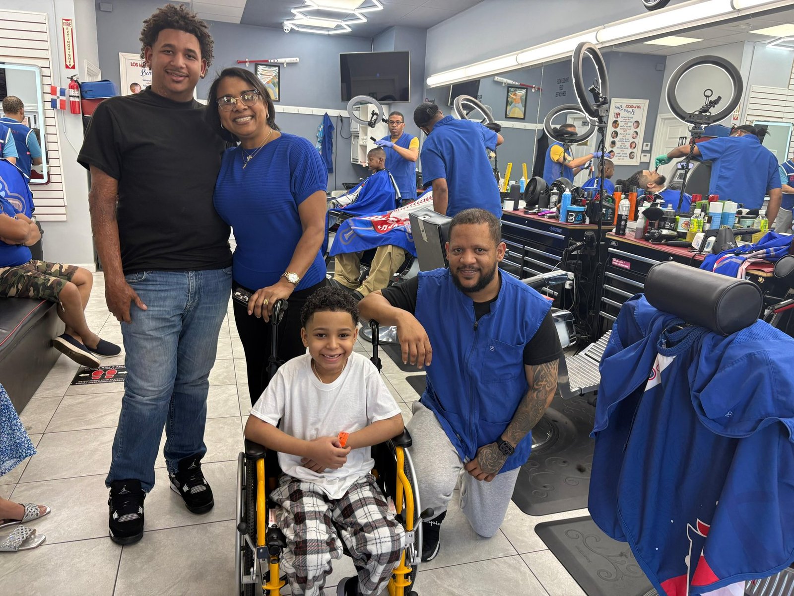 A family with their barber at a neighborhood barbershop