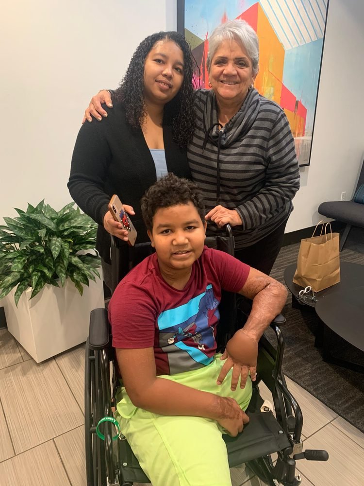 A boy in a wheelchair with his family