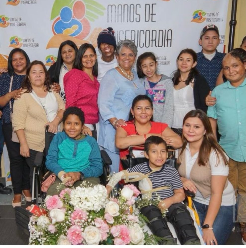 A large group gathered at the Manos de Misericordia banner