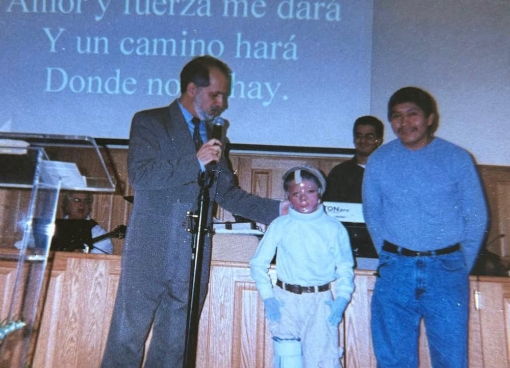 A boy on stage with community leaders at a church service