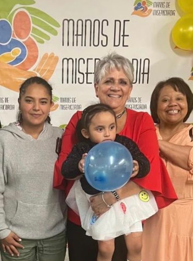 Martha Garzón holding a toddler with a balloon